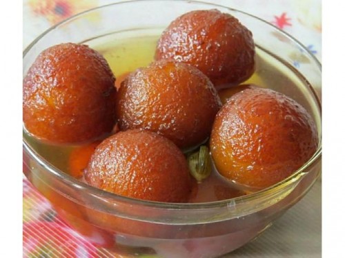 Recipe By Supritee
Soft, spongy and melt in mouth gulab jamuns...... drenched in delicately flavored sugar syrup is a traditional sweet in India...... No festival seems complete without it...... ...There are many ready-made Instant mixes available in market but no one comes even close to the taste of homemade gulab jamuns made from traditional khoya with my super hit recipe.....Yes, this recipe uses khoya to get the desired texture and flavor..... It also steers away from using rose flavored sugar syrup for more rich and delighting saffron flavored syrup.... . Make it from scratch today and shower your taste buds with its unforgettable taste.......

You require....
1/2 cup Maida....
1 cup grated Khoya/ 200gms....
1/8 tsp Baking Soda....
Ghee for deep frying...
3-4 Green Cardamoms...
8-10 Saffron Strands (kesar)....
1½ cups Sugar....
2½ cups Water

There are three different base items that are required for making this delicious sweet..... mawa, sugar syrup and gulab jamun itself......
Prepare Saffron Flavored Sugar Syrup....
Take 2½ cups sugar....
3-4 green cardamoms....
8-10 saffron strands in a deep pan.....

Add 2½ cups water and bring to boil.... reduce flame to medium and cook until sugar syrup is little sticky.... it will take around 10-12 minutes...... Stir occasionally in between...... Turn off the flame.....Sugar syrup is ready.....

Take khoya..... Crumble it using hand.....
Add 1/8 tsp baking soda and 1/2 cup sifted maida......
You will see the flour is easily mixed with mawa because of moisture in mawa...... Knead all of them together until smooth dough is prepared...... If required add a few teaspoons of milk to knead a smooth and soft dough (add one teaspoon milk at a time until smooth consistency of dough is achieved, do not add large amount in single go).......
Divide dough into 16-18 equal parts..... grease hands with ghee and make smooth surfaced balls from it...... Make sure that there is no crack on the surface of balls because it will make jamuns to crack open while deep frying.......If you are not able to form crack-less balls, then you need to make dough bit softer......To do this, add milk in dough, knead it again and roll the balls again. Do not make very large balls because they will increase in size after deep frying and soaking in syrup......
Heat ghee in a pan over medium flame. When ghee is medium hot, add a pinch of dough in hot ghee and if it comes upward immediately without changing it’s color, ghee is ready...... If it turns brown immediately.....ghee is too hot......deep fry the balls over low to medium flame.......you can see they will turn light golden and increase in size after a minute..... If the jamuns turn dark brown immediately then the temperature of ghee is too hot, pour some cold ghee in to ghee to reduce the temperature.......
After 3-4 minutes, they will turn light golden brown......
Deep fry until they turn golden brown, it will take around 6-7 minutes..... . Cooking them evenly is the key to soft and textured gulab jamuns...... increase or decrease flame intensity to keep the temperature of ghee even while frying them....... Drain and transfer them over kitchen napkin and let them cool for 5-minutes.......the balls are increased in size after deep frying......Do not add them directly into warm sugar syrup.....
Add fried balls into warm sugar syrup (not hot syrup). If you add them into hot syrup, they will shrink in size........

Soak them for at least 1-2 hours before serving..... . As you can see in the picture, the jammuns are increased to almost double in size. Gulab jamuns are ready for serving. Serve them warm or chilled......