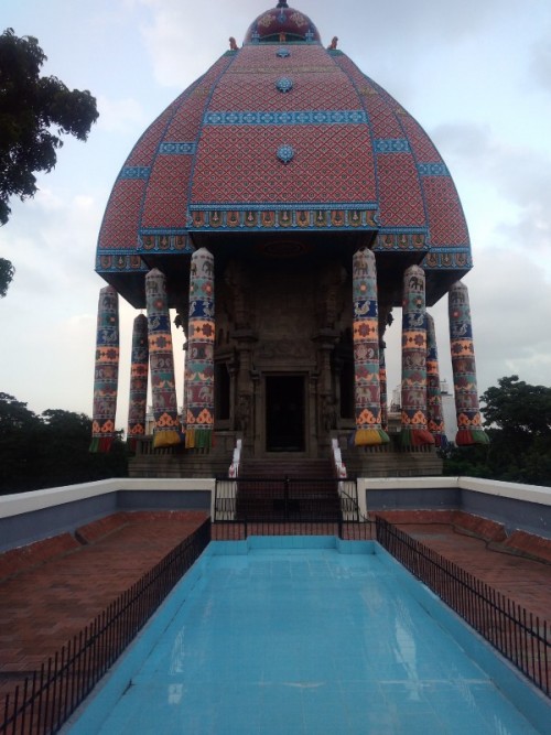 Valluvar Kottam is located at the intersection of the Kodambakkam High road and the Village road in Nungambakkam neighbourhood of Chennai. The monument now stands at what was once the deepest point of a local lake called the Nungambakkam lake.
The monument consists of a decorative arch, an auditorium that can accommodate around 3,500 people, and the Kural Manimandapam, where all the 1,330 couplets from all 133 chapters of the Kural literature are inscribed on bas-relief. The hallmark of the monument is the 39-meter-high (128 feet) stone car, a replica of the famed temple chariot of Thiruvarur. The chariot is made of around 3000 blocks of stone. The four giant-sized wheels of the chariot measure 11 feet in diameter and 2 feet in thickness.[3] A life-size statue of Valluvar has been installed in the chariot. The chariot is adorned with the famed Kalamkari drawings.

https://en.wikipedia.org/wiki/Valluvar_Kottam