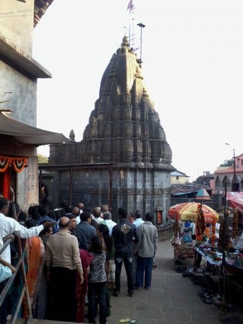 Bhimashankar Temple is a Jyotirlinga shrine located 50 km northwest of Khed (alias Rajgurunagar), near Pune, in India. It is located 127 km from Shivajinagar (in Pune) in the Ghat region of the Sahyadri Mountains. Bhīmāshankar is also the source of the river Bhima, which flows southeast and merges with the Krishna river near Raichur.
As per the Shiv Mahapuran, once Brahma (the Hindu God for creation) and Vishnu (the Hindu God for protection) had an argument about creation. To test them, Shiva pierced the three worlds as a huge endless pillar of light, the jyotirlinga. Vishnu and Brahma split their ways to search downwards and upwards respectively to find the end of the light in either direction. Brahma lied that he found out where it ends, while Vishnu conceded defeat. Shiva appeared as the second pillar of light and cursed Brahma that He would have no place in ceremonies while Vishnu would be worshipped till the end of eternity. The jyotirlinga is the supreme partless reality, out of which Shiva partly appears. The jyotirlinga shrines, thus are places where Shiva appeared as a fiery column of light.